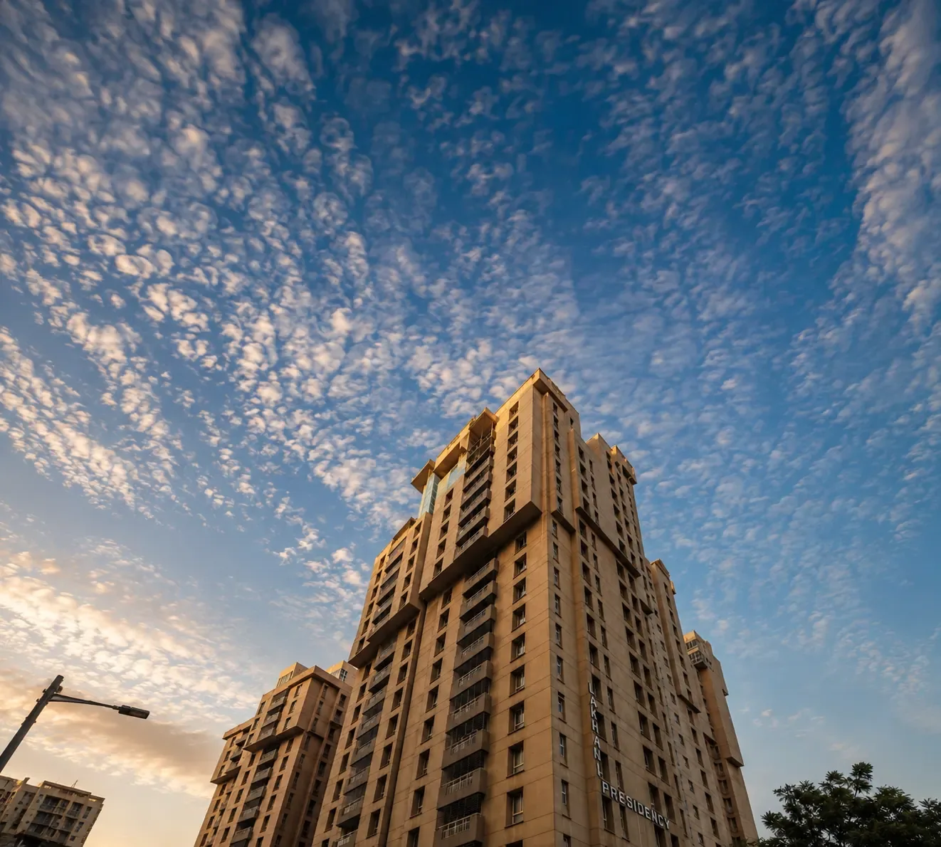 The tower shot from directly below against a broken cloud sky.