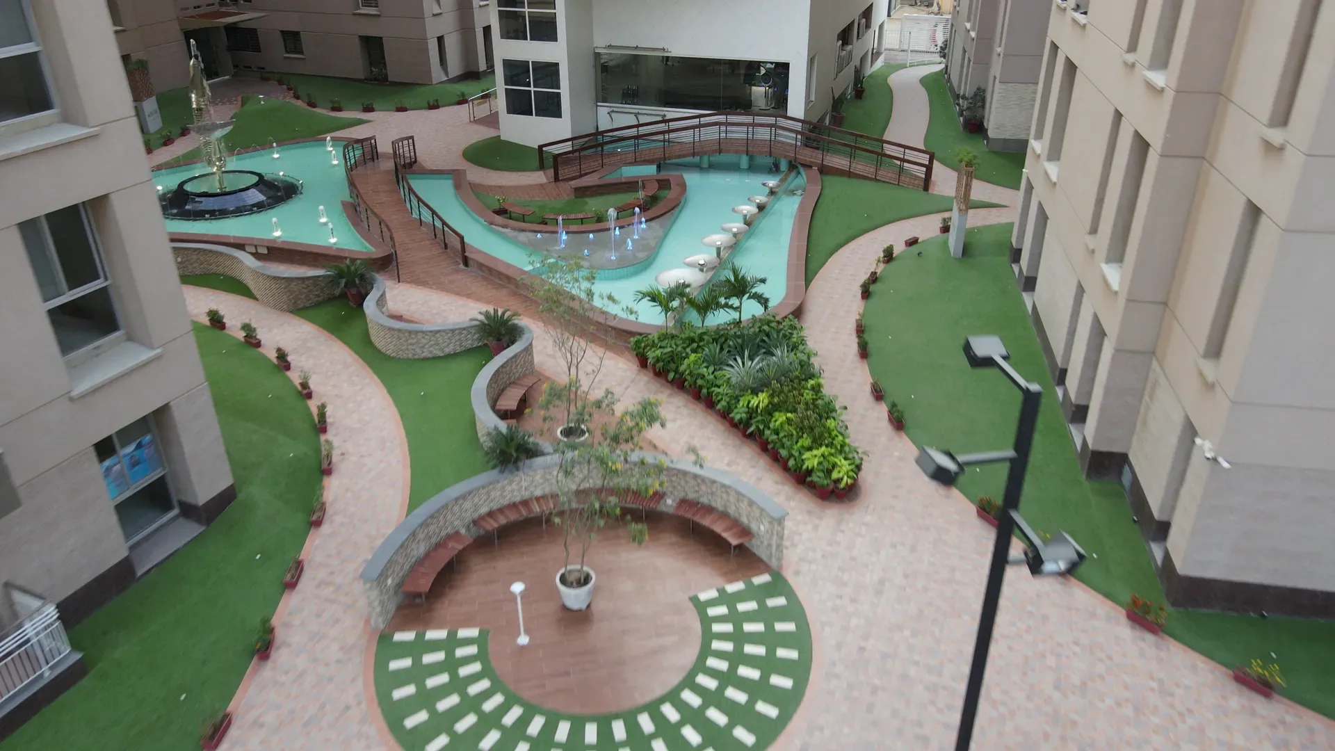 The whole podium, water, lawn and promenade laid out between the towers.