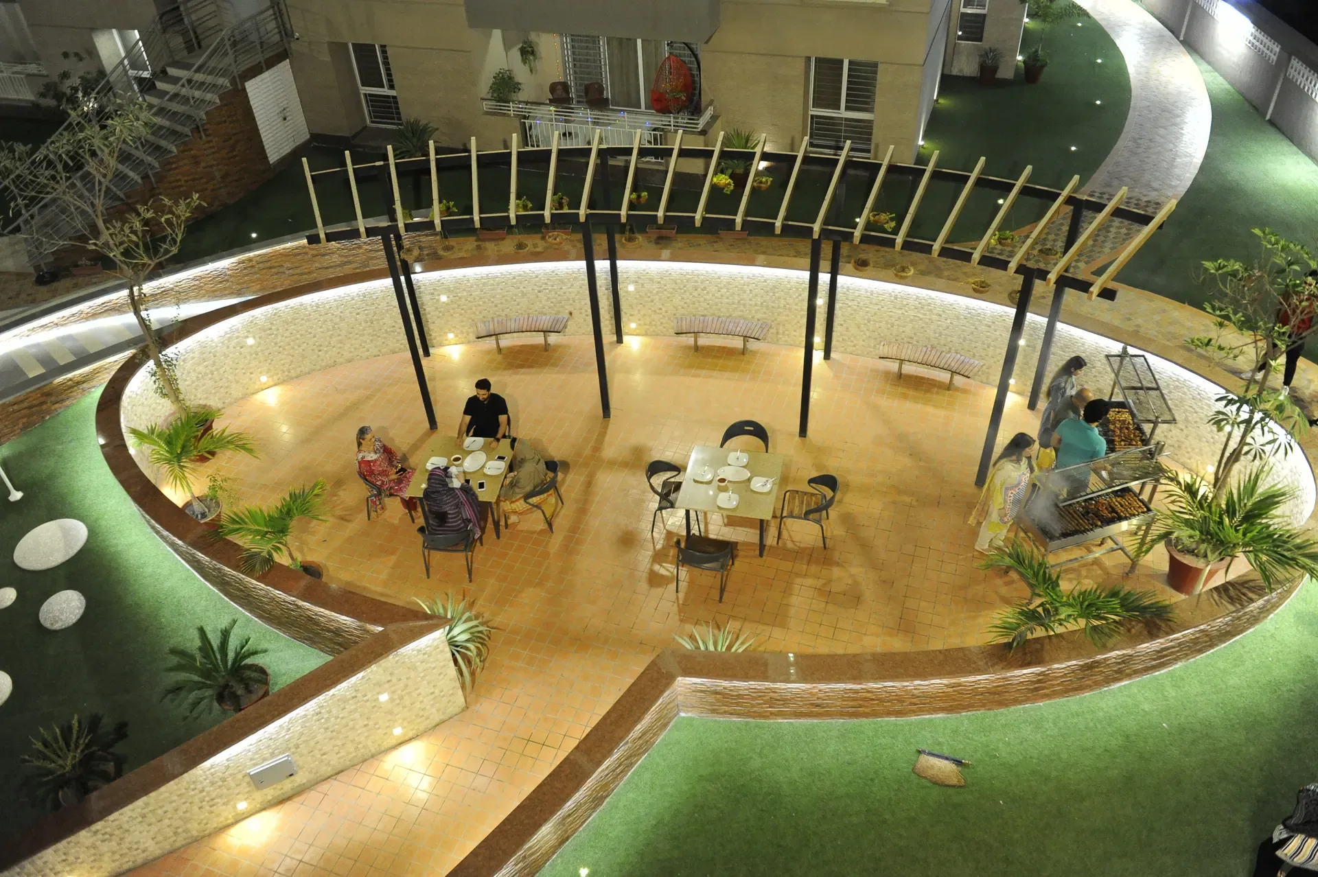 The circular courtyard from above — seating under pergolas, planting all round the rim.