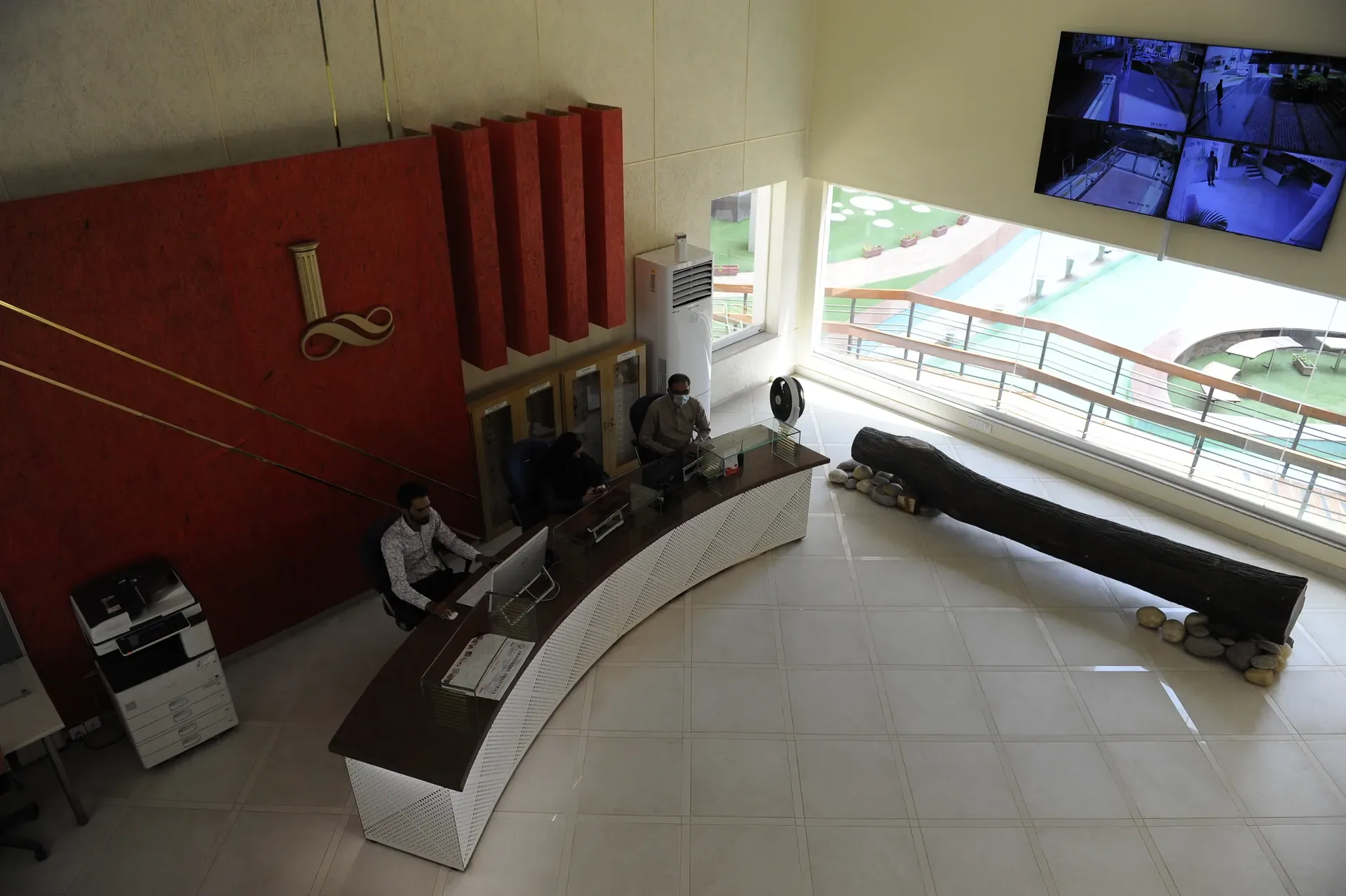The reception hall, a curved counter under a deep red wall.